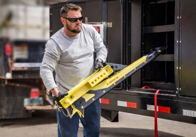 An operator carrying a yellow barrier unit.