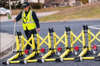 An operator deploying connected yellow barriers.