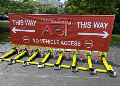 Vehicle barriers beside directional signs.